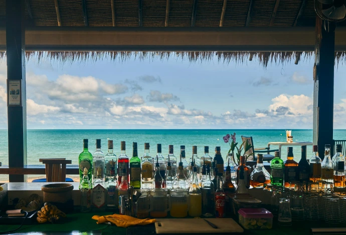 a bar with bottles of alcohol on the beach